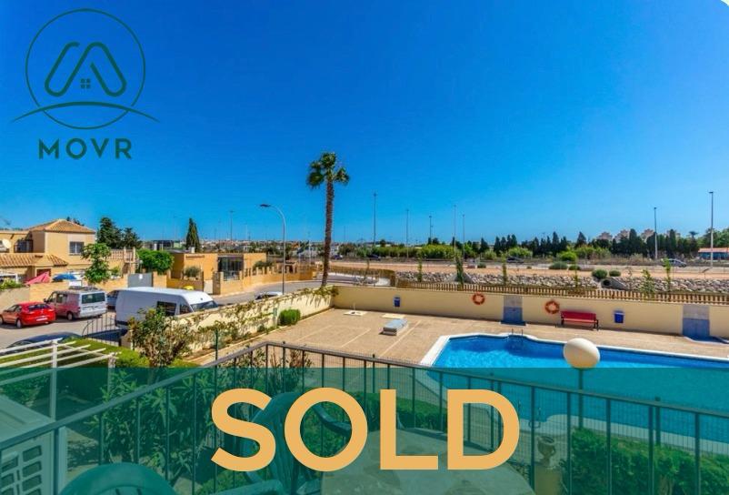 Balcony view over a communal pool terrace previously sold by MOVR in Orihuela Costa