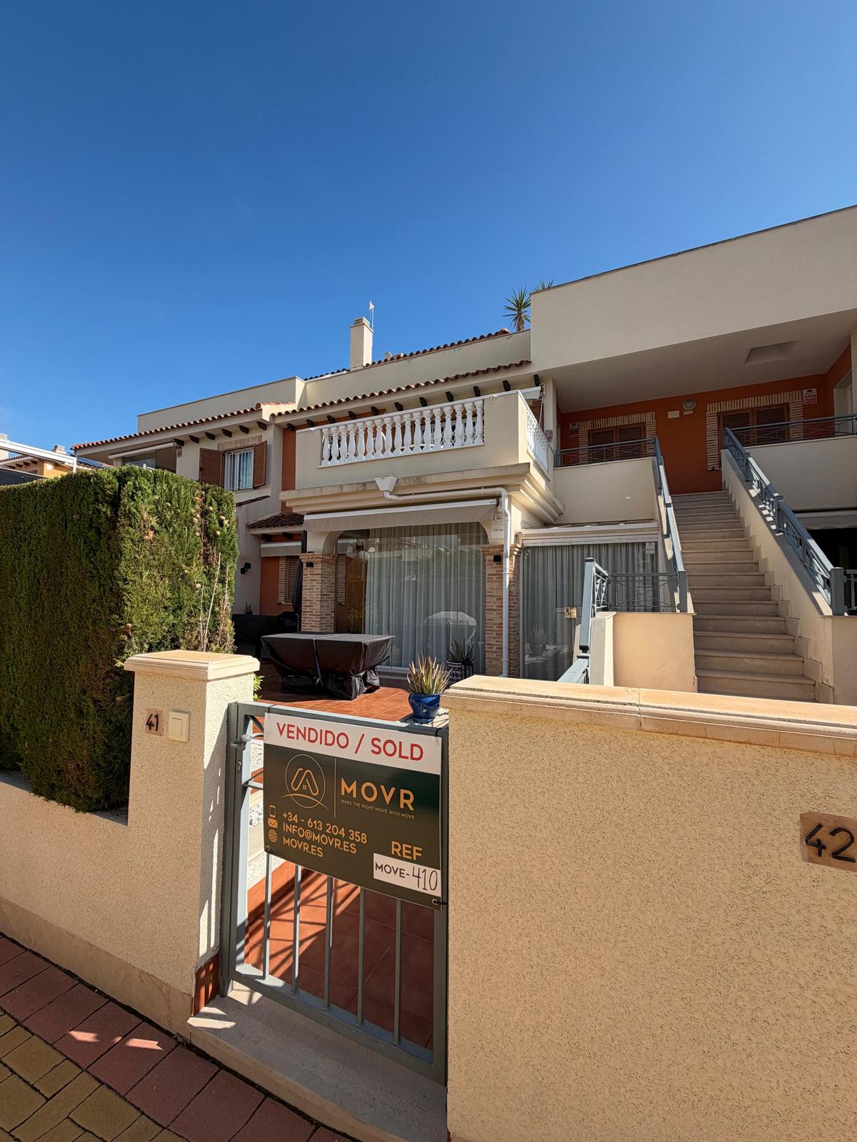 Ground-floor apartment in Zeniamar IX, Playa Flamenca, with a MOVR Vendido / Sold board outside; sale agreed