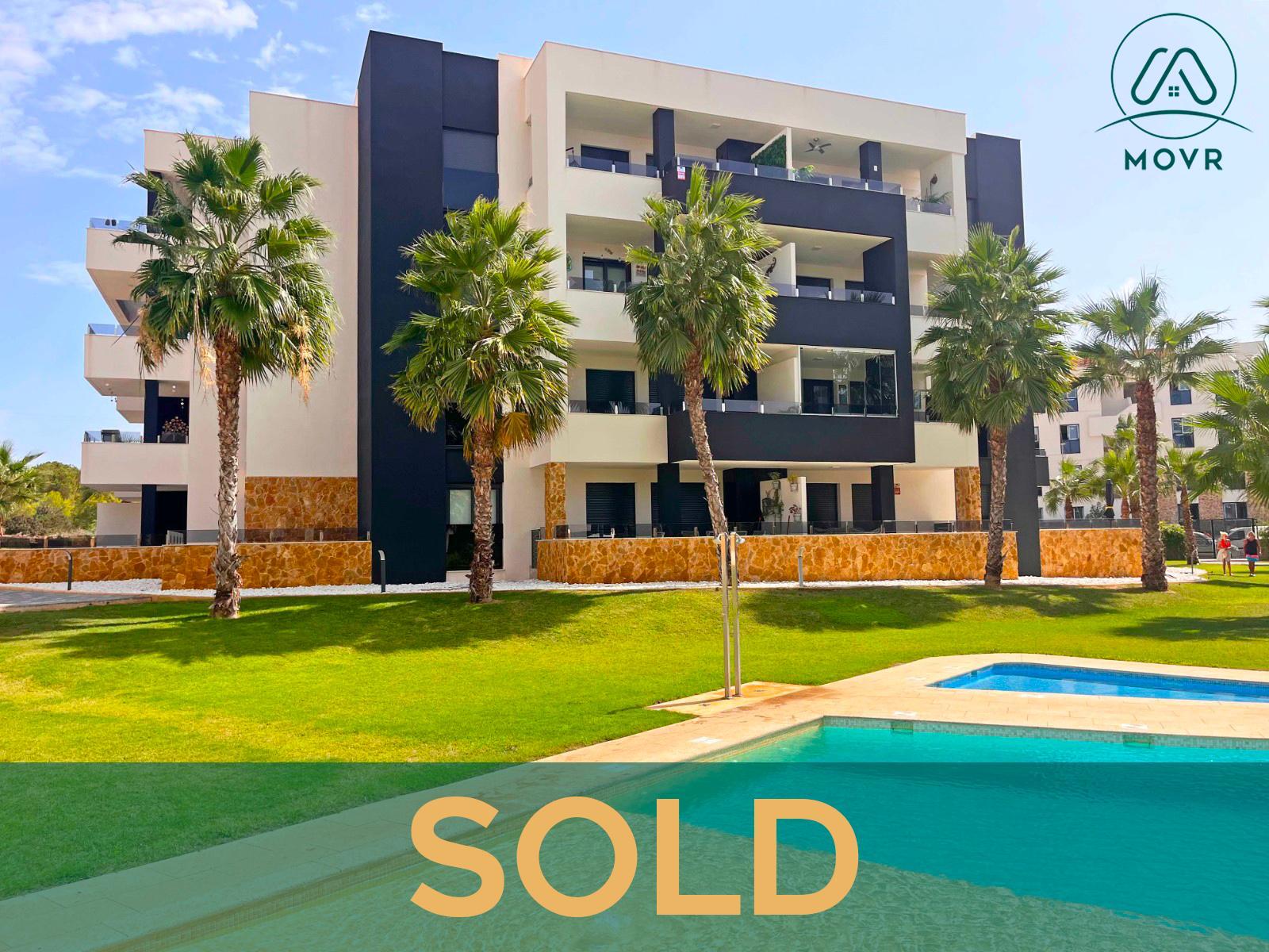 Modern apartment block with palm-lined lawns and pools previously sold by MOVR in Orihuela Costa