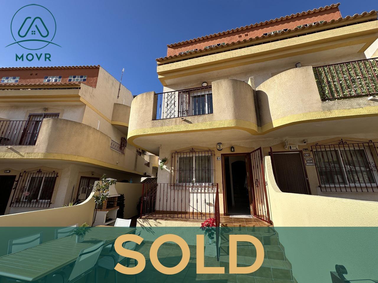 Yellow townhouse with curved balconies and a front terrace previously sold by MOVR in Orihuela Costa